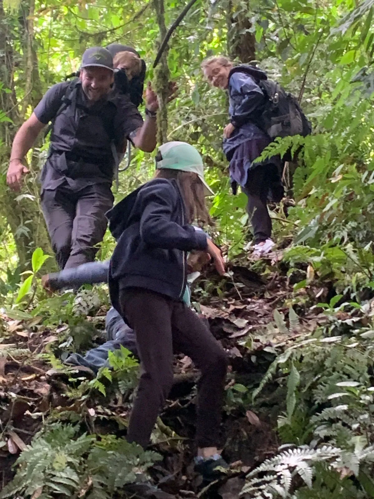 A family laughing on the way down, the youngest in a carrier