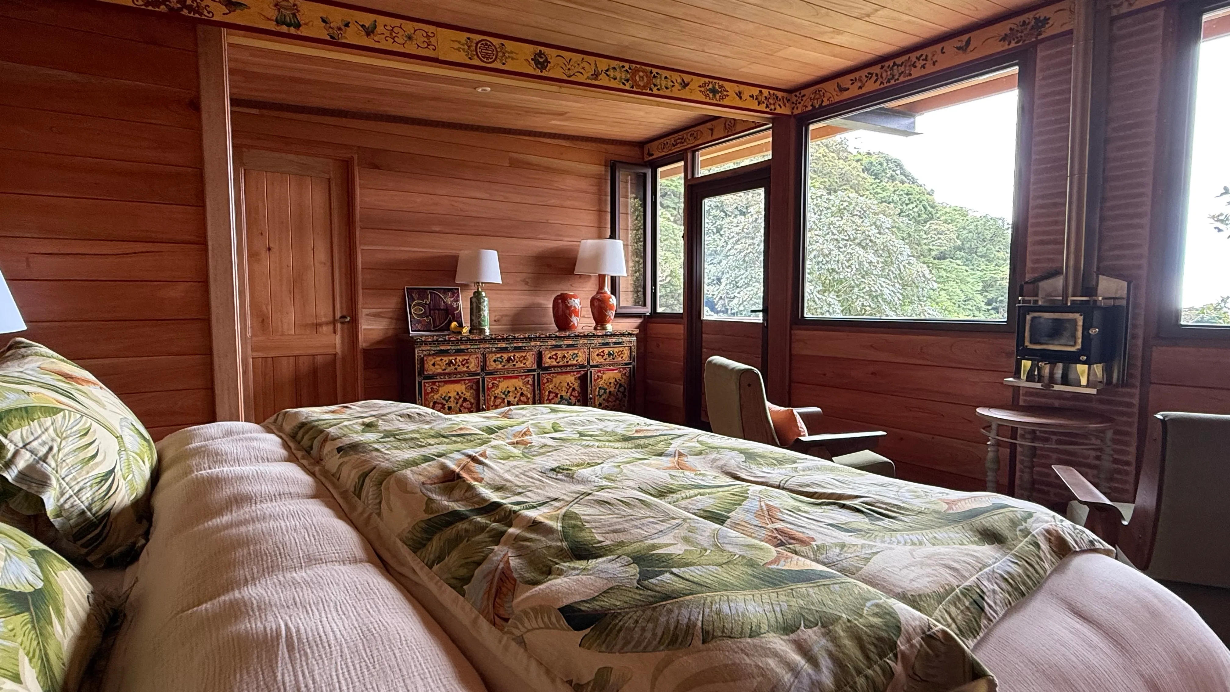 Cabin Jaguar bedroom with wood stove and forest view