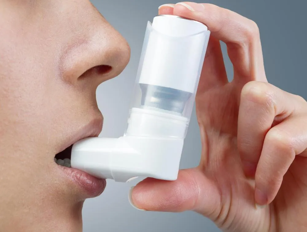 A young woman using an inhaler